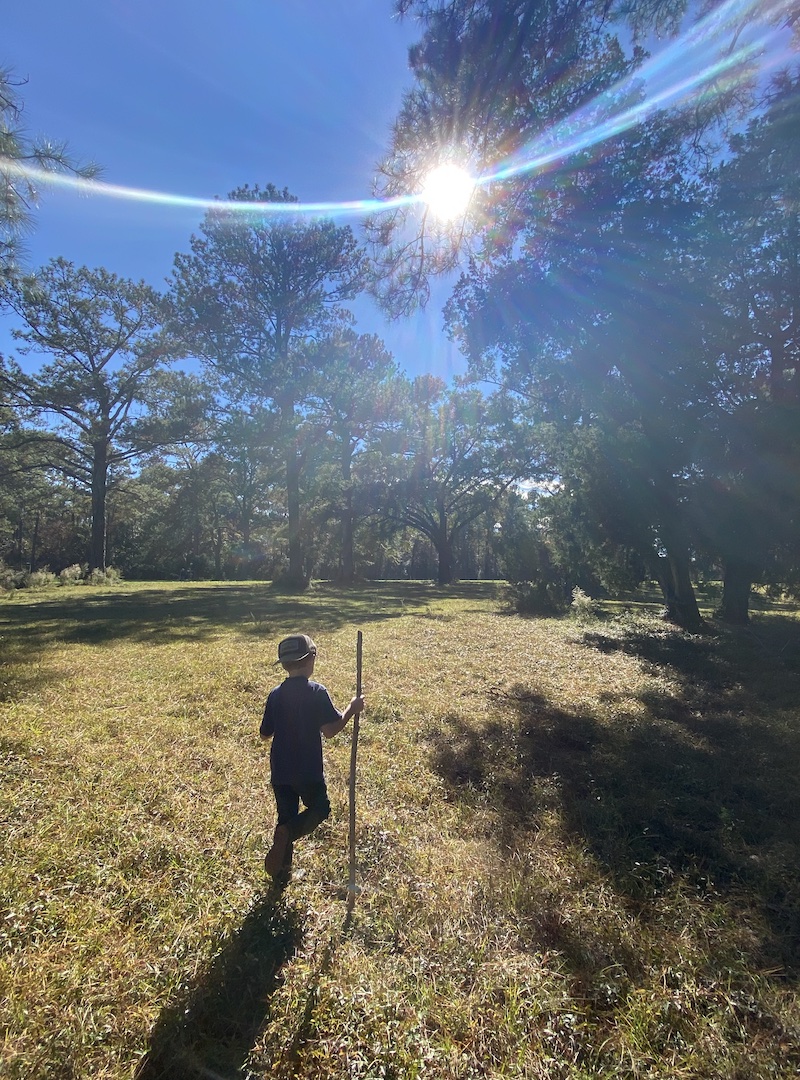 A young boy hikes through a field in the Woodlawn neighborhood of DeFuniak Springs on a property adjacent to the proposed Emerald Coast Motor Club private racetrack. 