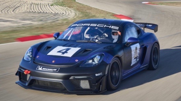 Porsche 718 Cayman GT4 RS MR A beautiful track racing car, teh Porsche 718 Caymen speeds along a track with mountains in the background.